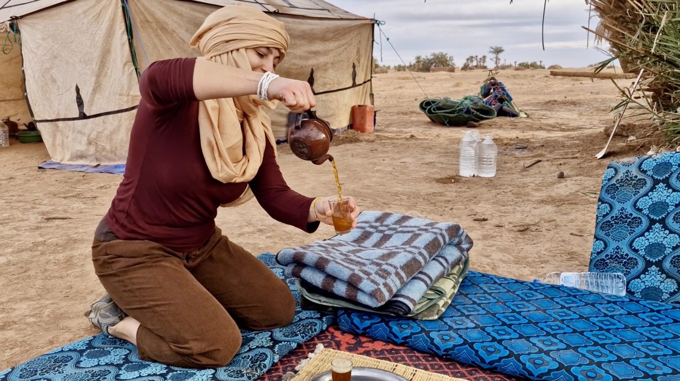 Vera gießt marokkanischen Tee im Wüstencamp
